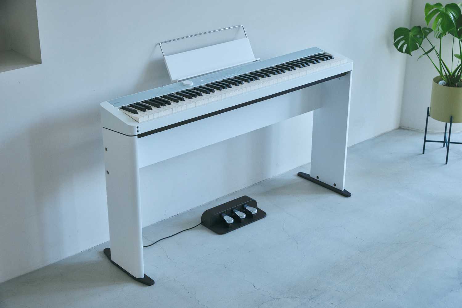 Casio Privia PX-S1100CB mit Stand und Pedal an der Wand Casio Privia PX-S1100CB Lifestyle Klavier mit Ständer und Pedal steht an der Wand