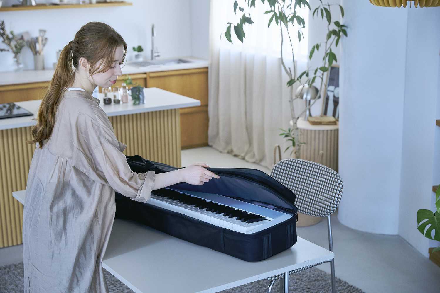 Casio Privia PX-S1100CB mit Tasche Casio Privia PX-S1100CB Lifestyle Frau öffnet Tasche mit Klavier